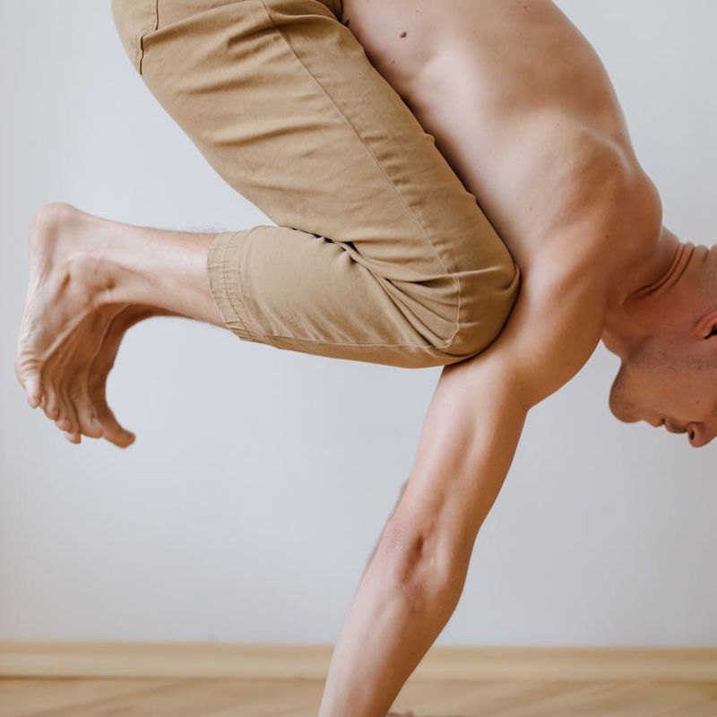 Person holding a difficult balancing pose, showing strength and control.