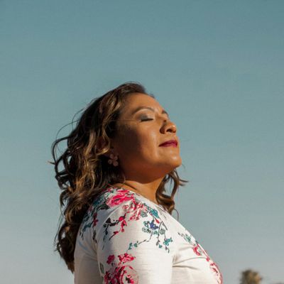 Silhouette breathing deeply with chest expanded against a window.